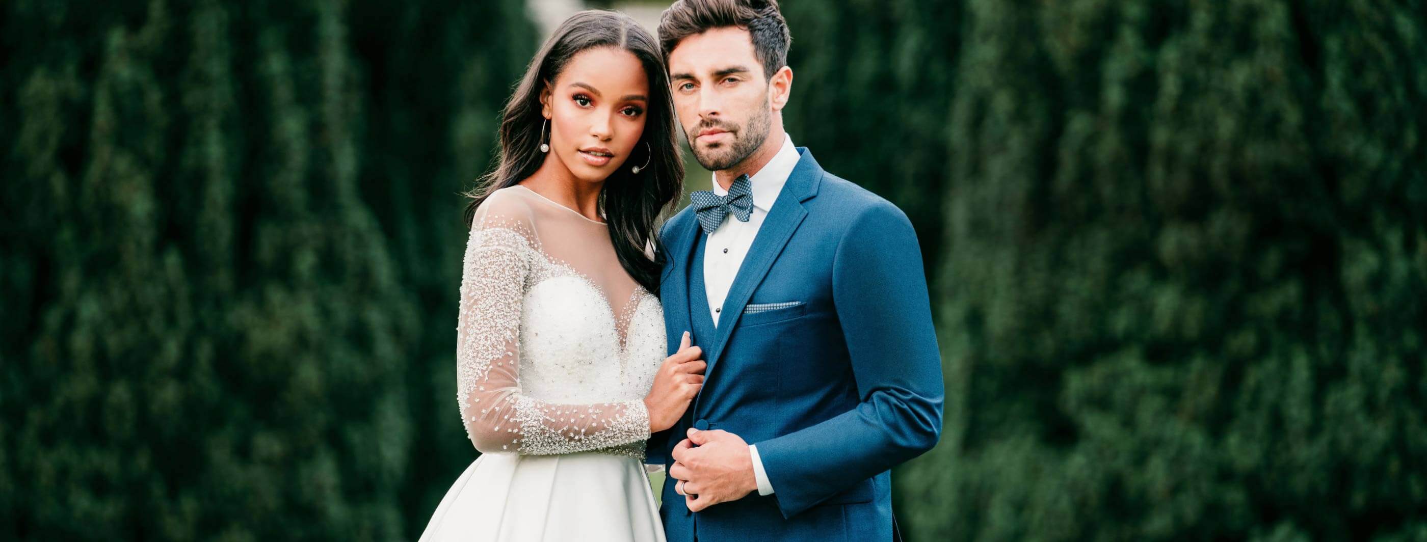 Сouple wearing a white gown and a dark blue suit