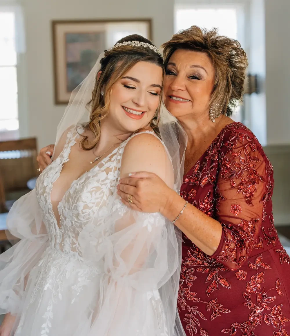 Bride and mother wearing a white gown and a red gown